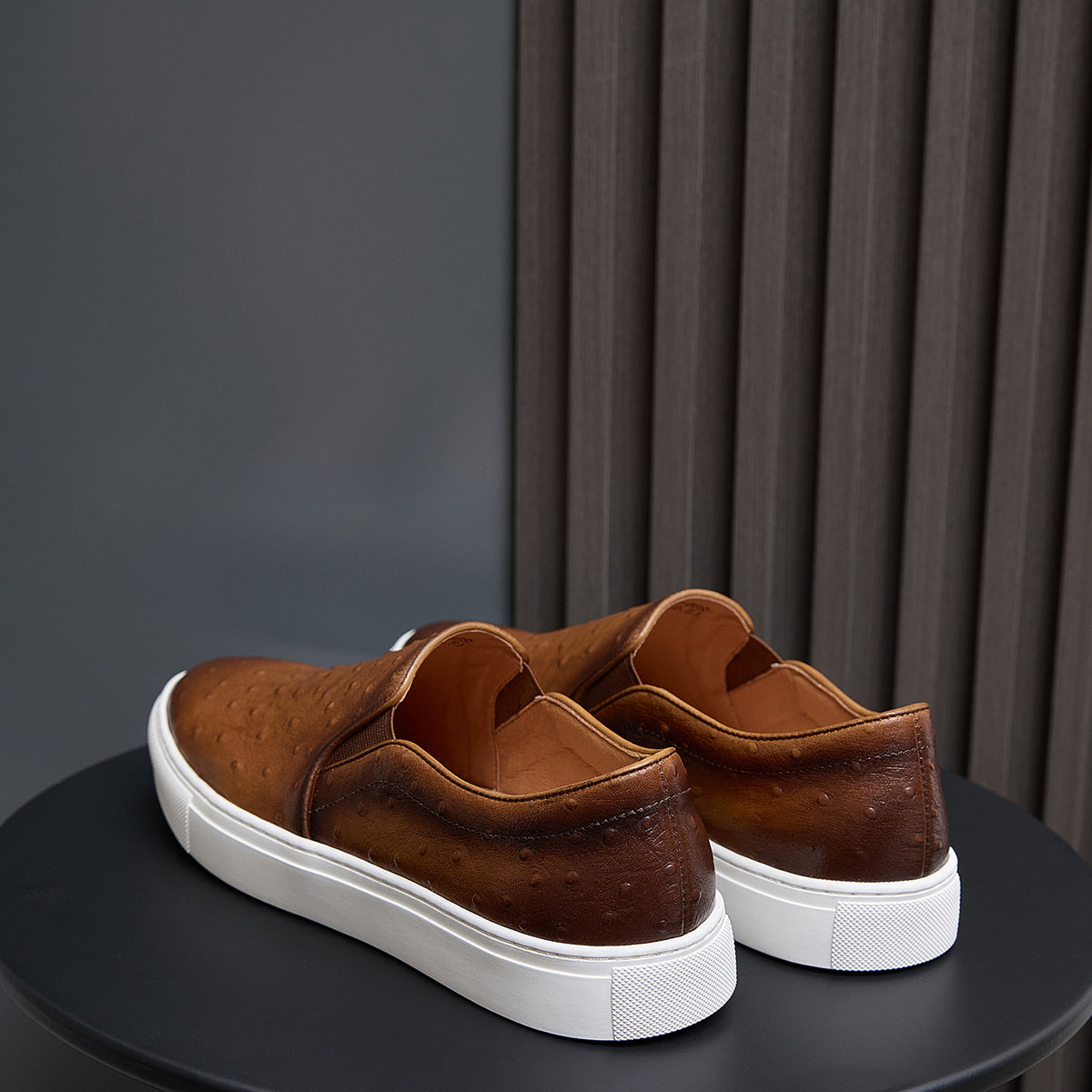 Brown leather slip-on sneakers rear view with padded heel and white rubber sole