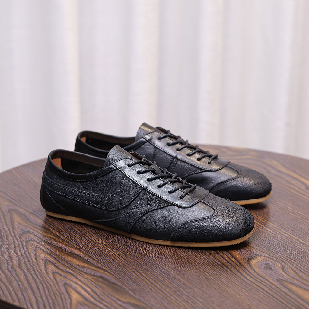 Men's black leather sneakers, side angle view with lace-up closure and gum sole