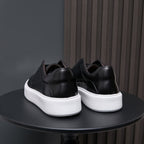 Men's genuine leather sneakers in black, rear view with white midsole platform.