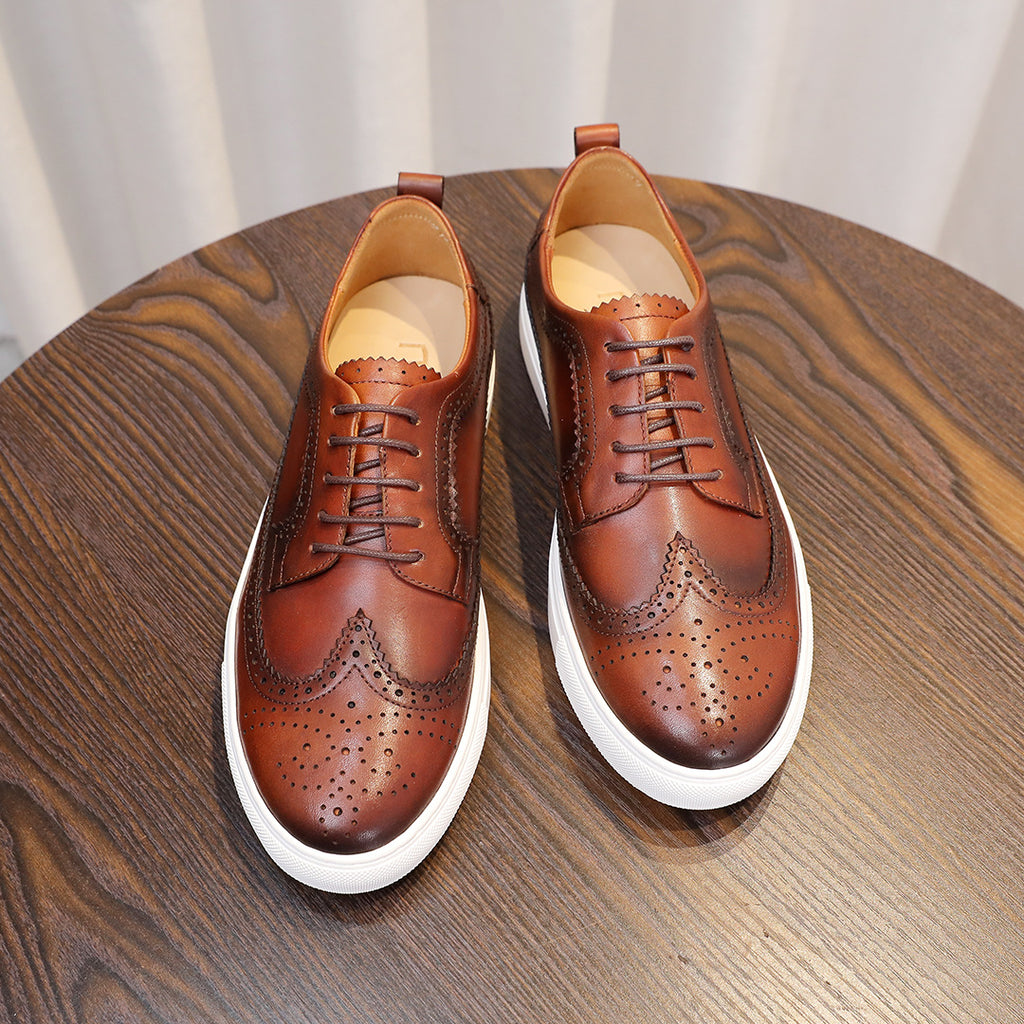 Brown leather lace-up sneakers, wingtip perforations, tongue lining visible