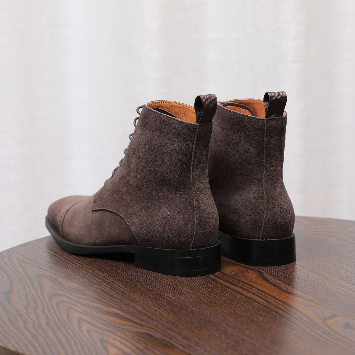 Pair of dark brown suede chukka boots with black heel and side seams