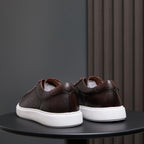 Back view of dark brown leather sneakers with white rubber soles