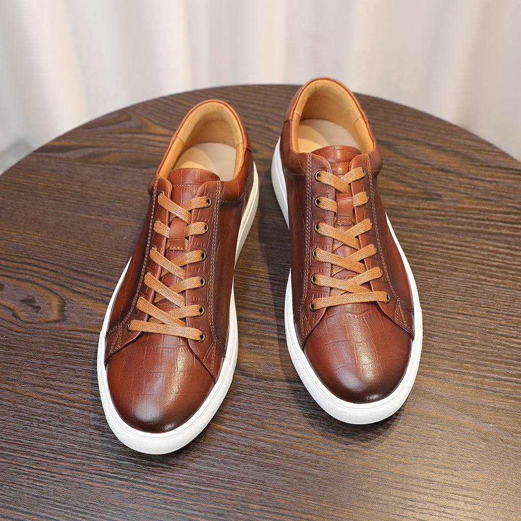 Men's brown genuine leather sneakers, front view with lace-up design and white sole.