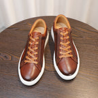 Men's brown genuine leather sneakers, front view with lace-up design and white sole.
