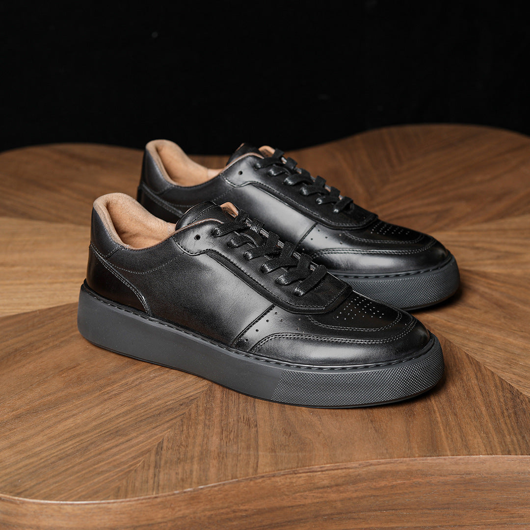 Black leather sneakers, two-shoe side view with lace-up front and cushioned collar