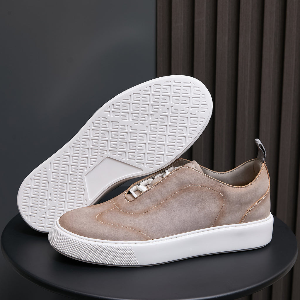 Light taupe leather sneakers with white outsole tread showing underfoot