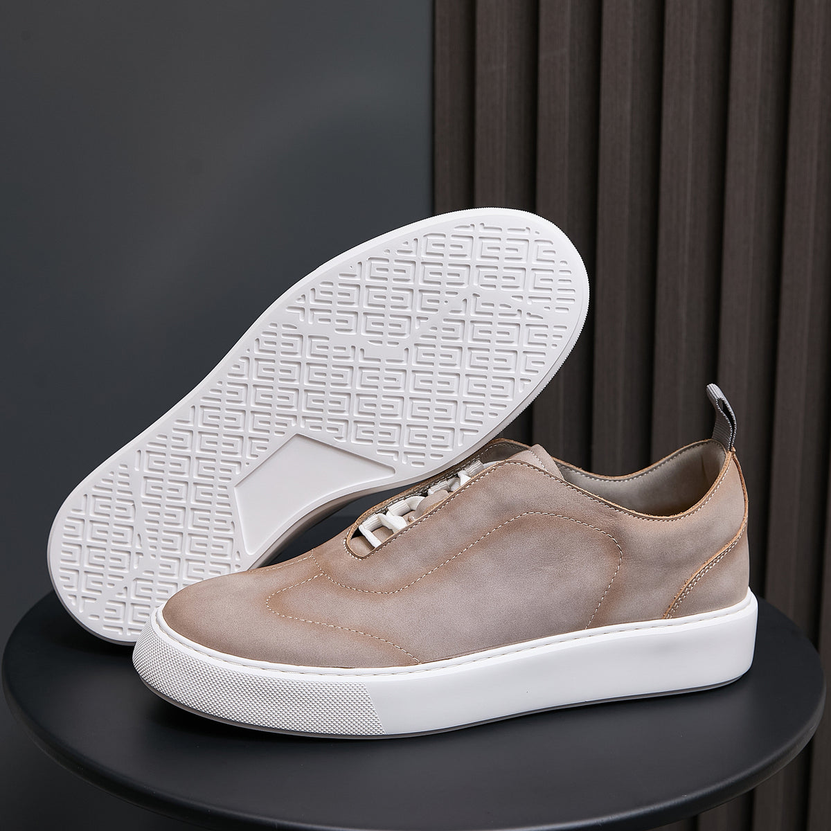 Light taupe leather sneakers with white outsole tread showing underfoot