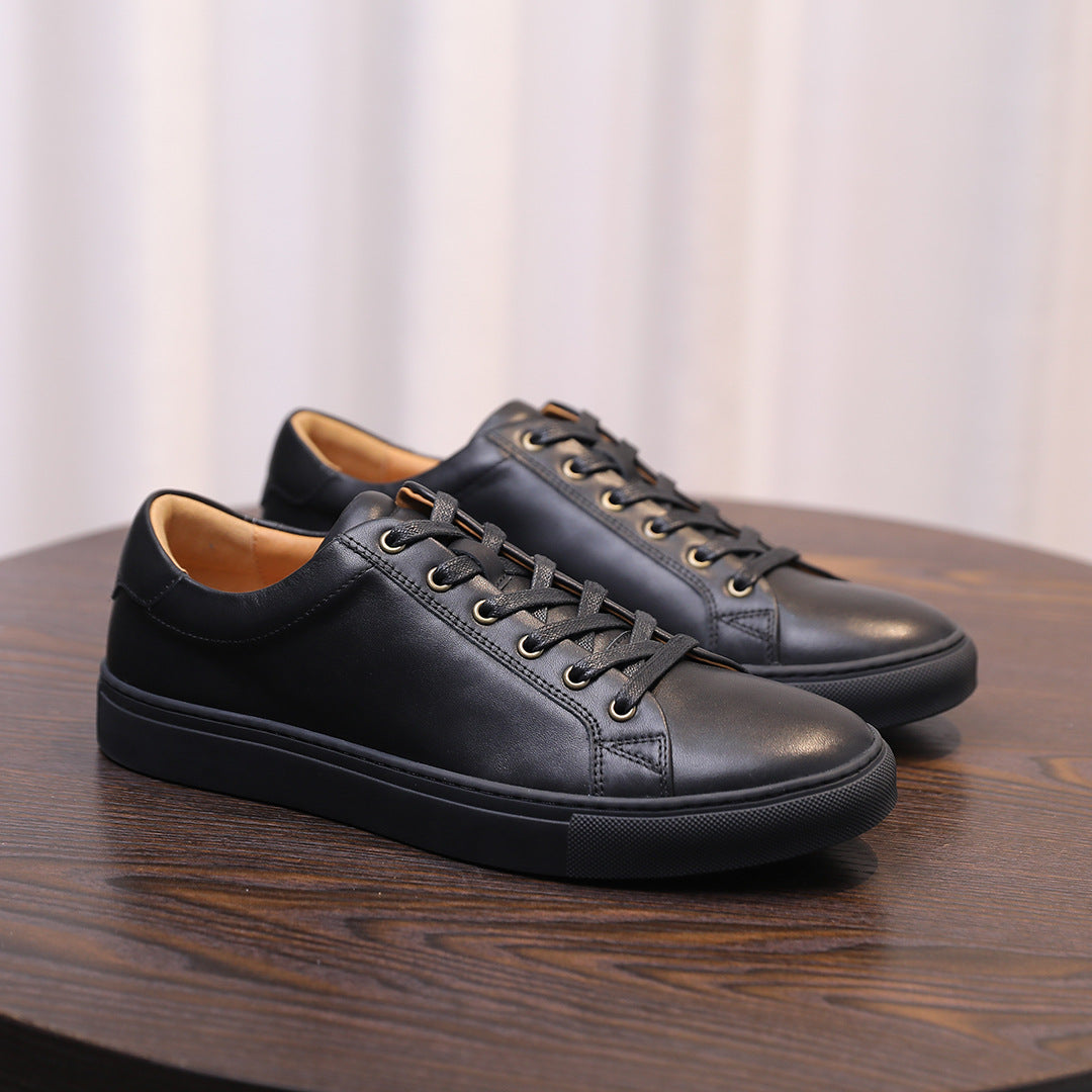 Men's genuine leather sneakers, black lace-up low-tops, angled pair view.
