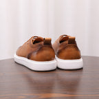 Brown leather low-top sneakers shown from the back, with lace-up and white sole