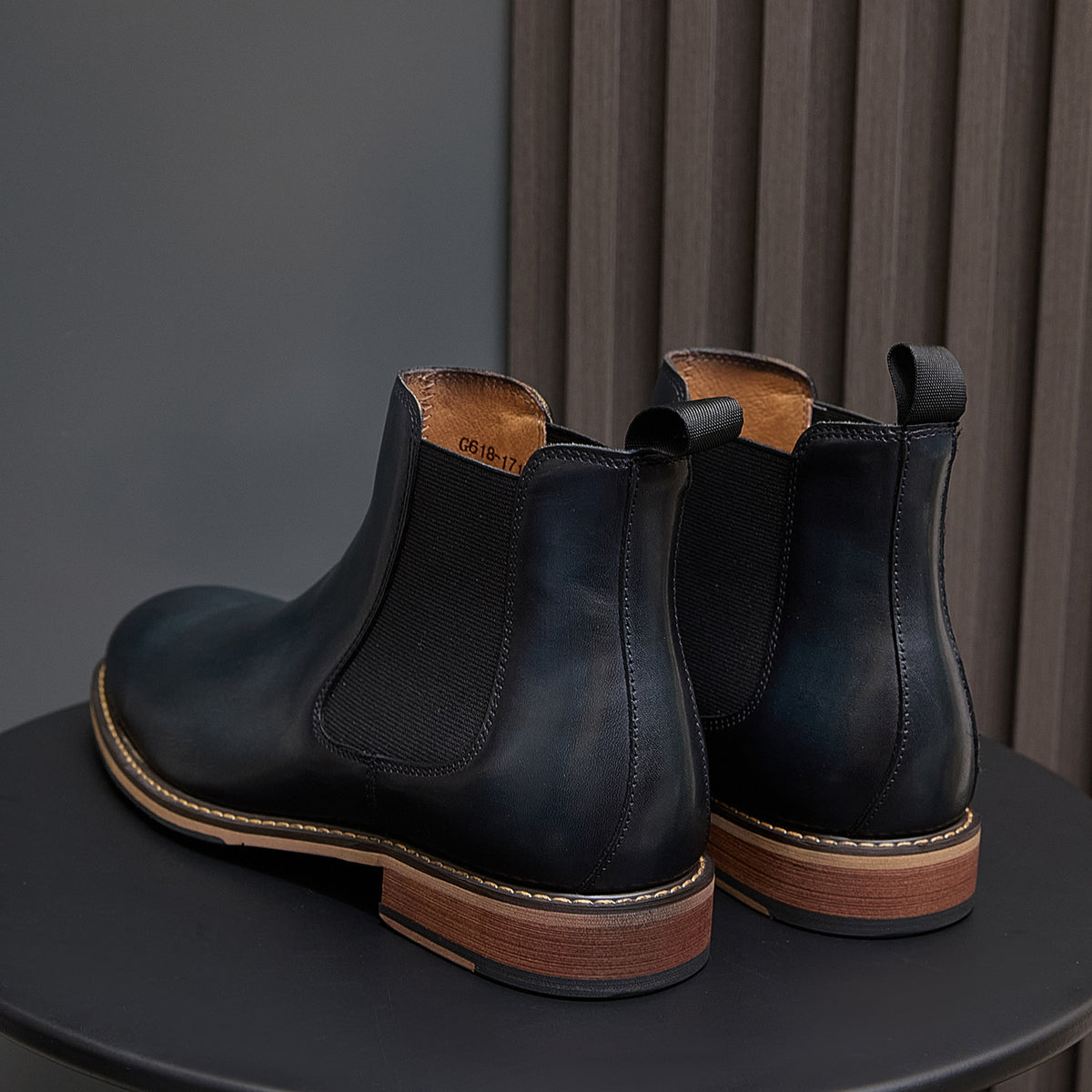 Pair of dark blue Chelsea dress boots with pull tabs, side elastic, and wood-tone sole