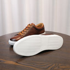 Men's brown genuine leather sneakers, side and outsole view with white sole.