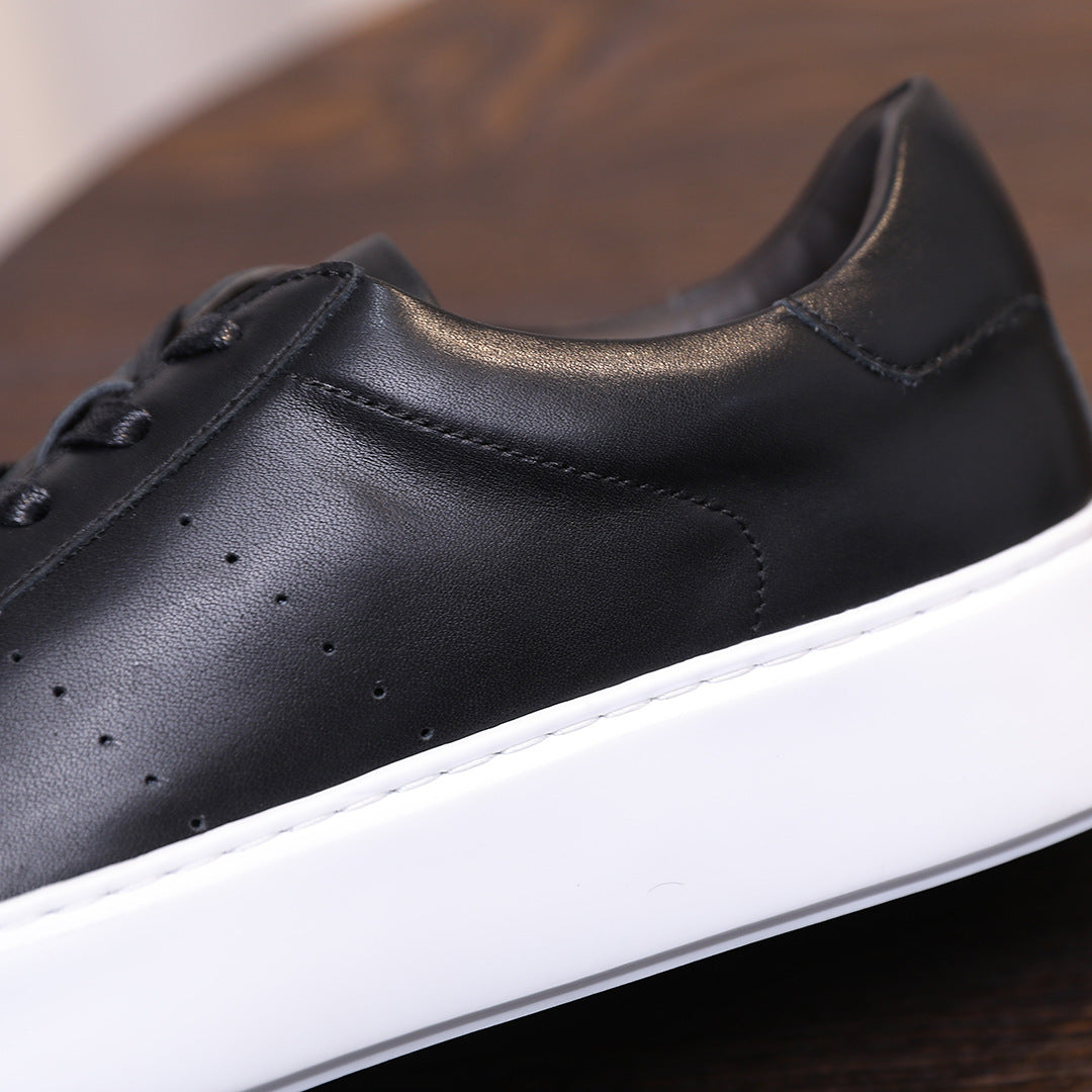 Men's black leather sneaker, side profile with perforated toe and contrast white edge
