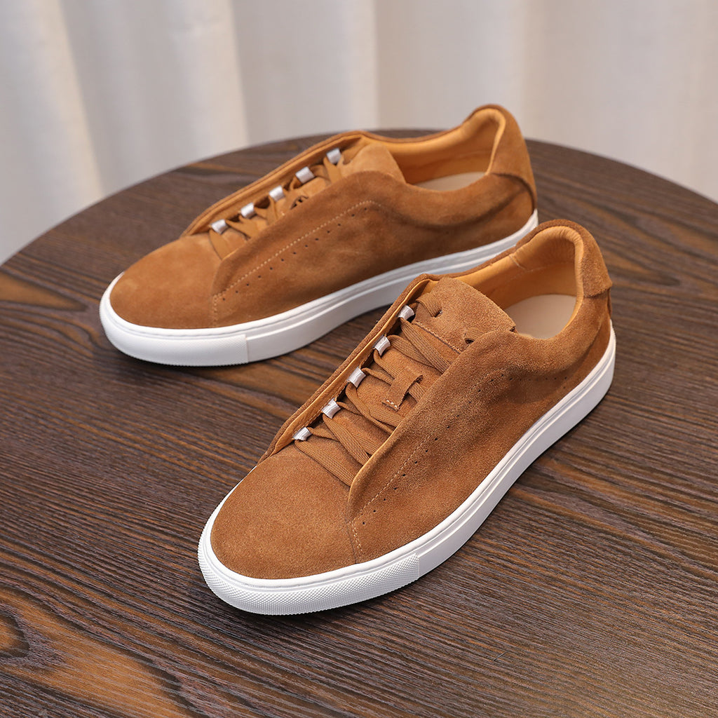 Men's brown suede leather sneakers with lace-up front and white rubber sole.