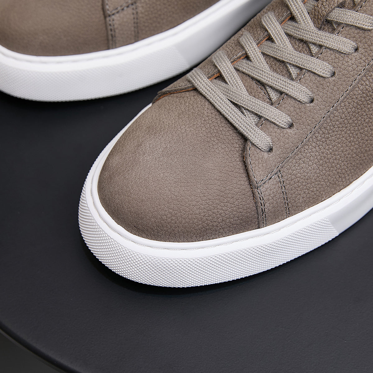 Men's genuine leather sneakers, taupe, close-up of laces, stitched seams, and white sole