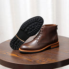 Dark brown leather lace-up ankle boot with pointed toe and visible rubber outsole tread