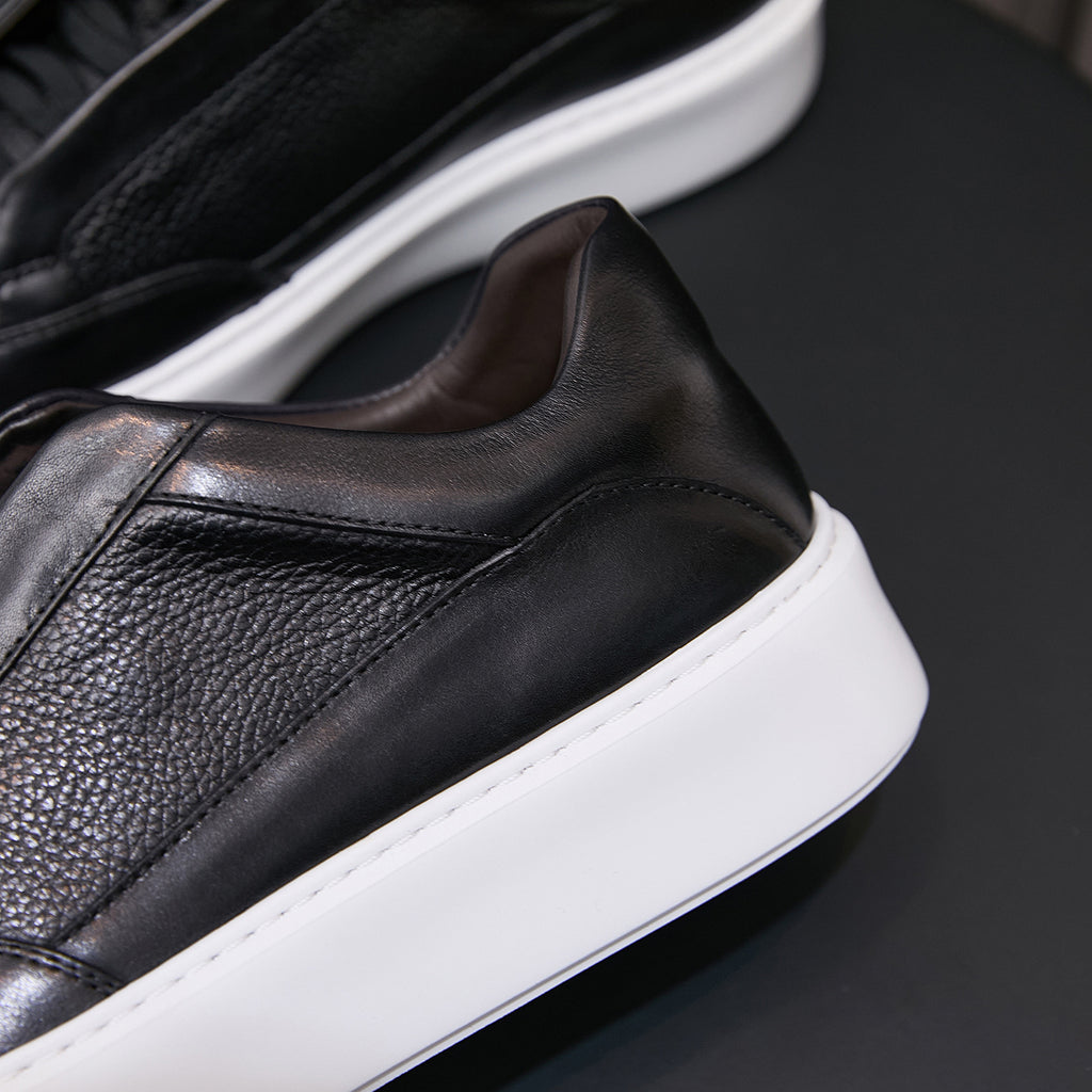 Men's genuine leather sneakers in black, side profile with textured upper and white sole.