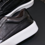 Men's genuine leather sneakers in black, side profile with textured upper and white sole.