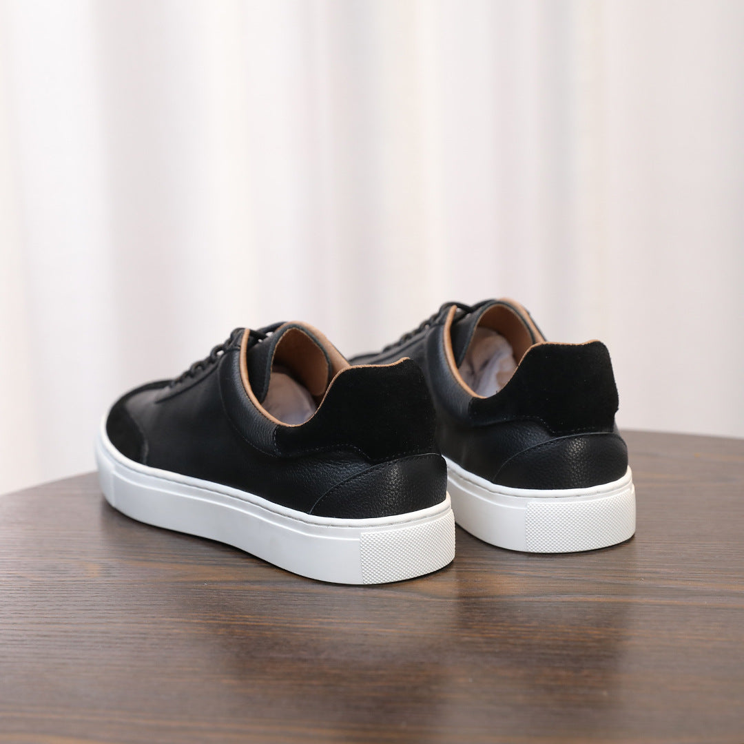 Men's black leather sneakers, rear view showing heel tab and white rubber sole.