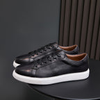 Black leather low-top sneakers with lace-up front and white rubber sole