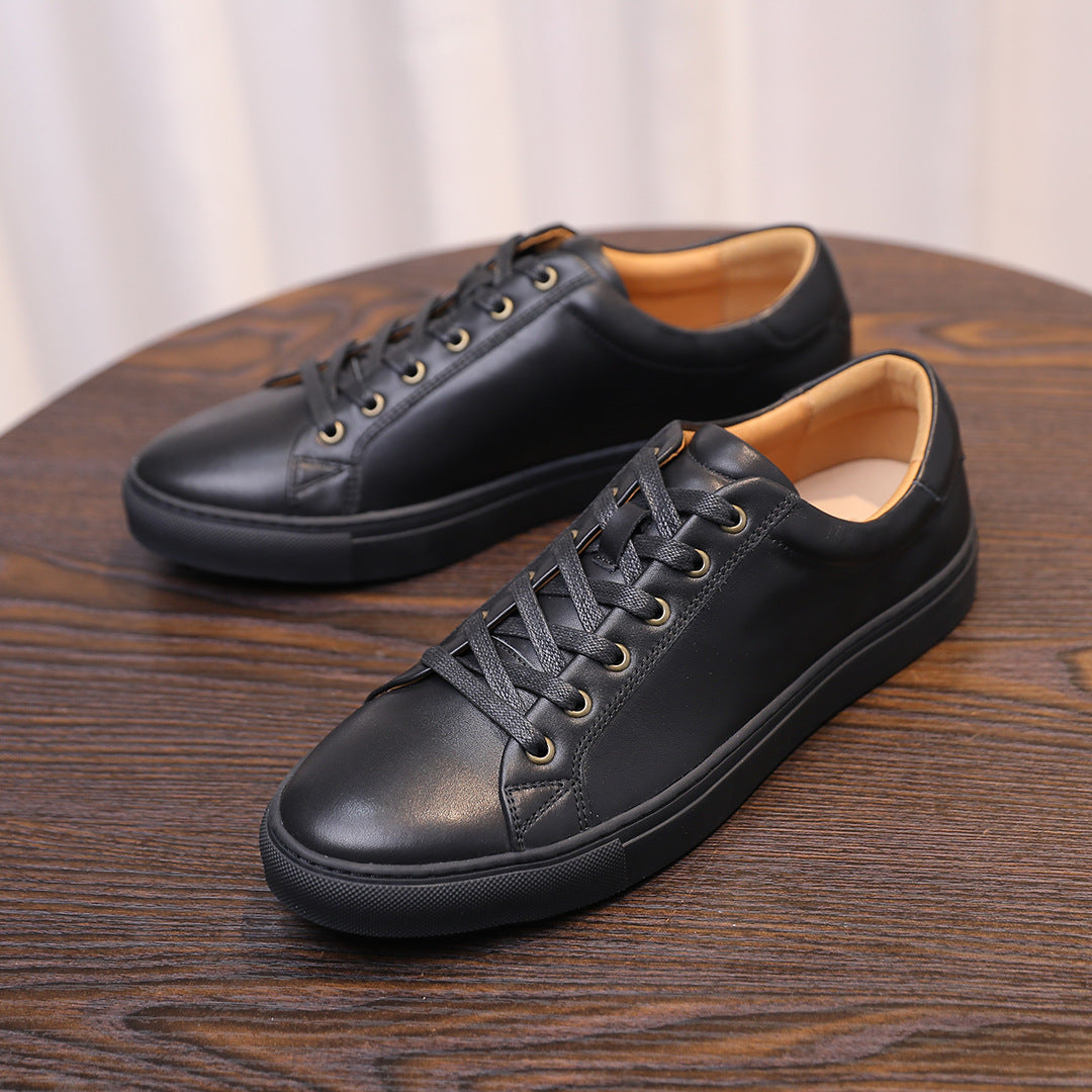 Black leather low-top sneakers with lace-up front and tan lining inside.