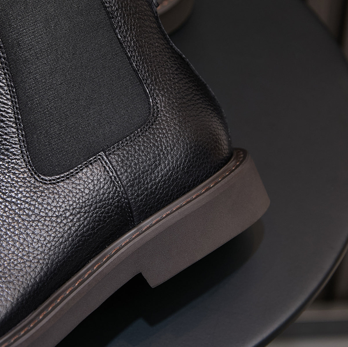 Men's black Chelsea dress boots, side view showing elastic gore and textured finish