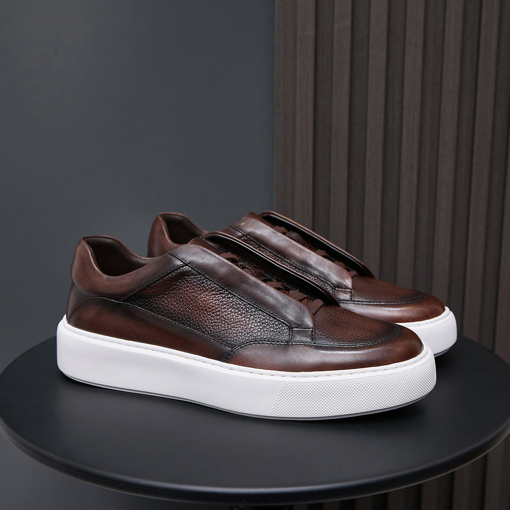 Men's genuine leather sneakers in dark brown with strap detail and white sole.