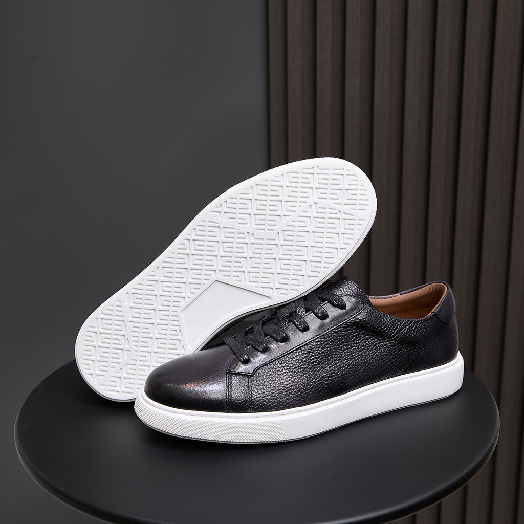 Black leather sneaker showing white outsole tread and lace-up upper