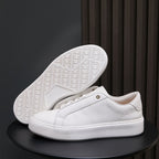 White leather sneakers with white outsole and textured tread pattern underside