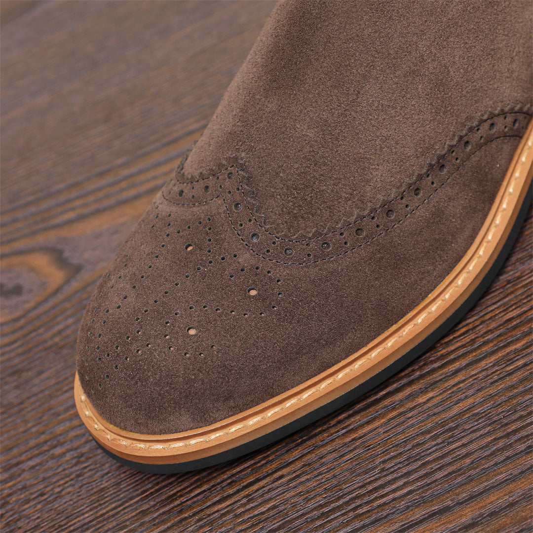Brown suede pointed-toe Chelsea boot toe with brogue-style perforations and tan trim