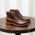 Dark brown leather pointed-cap toe ankle boots with lace-up front and orange welt