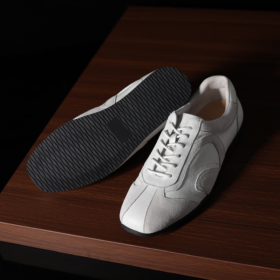 Men's white leather low-top sneakers with lace-up front and contrast side panel.