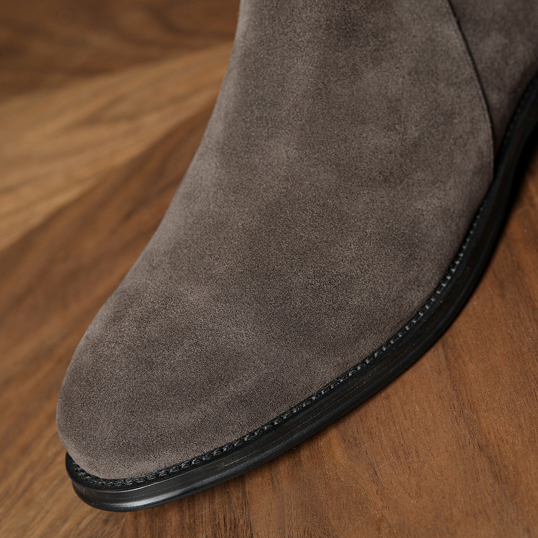 Close-up of men's dark gray suede boot upper with side zipper and stitched welt