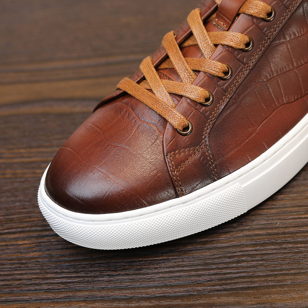 Men's brown genuine leather sneakers, close-up of toe, lace-up, and white sole.