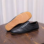 Men's black leather sneakers with lace-up front and visible tread outsole