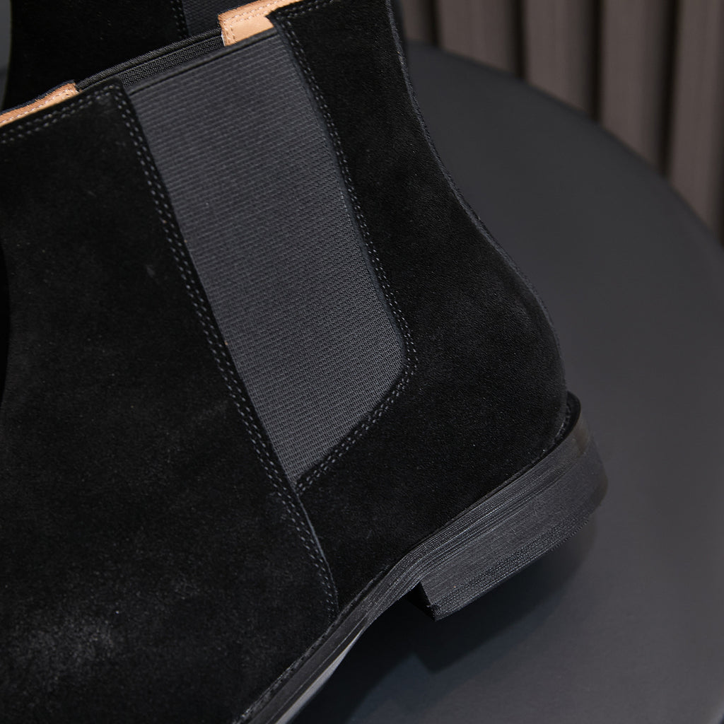 Side view of black suede Chelsea boot with elastic gore panel and low heel