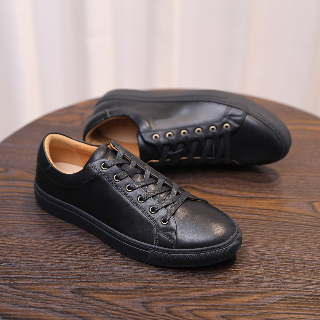 Black leather casual sneakers, side view showing lace-up design and stitched seams.