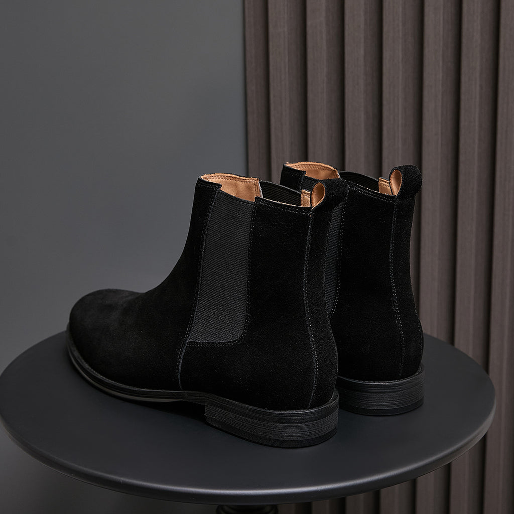 Back view of black suede Chelsea boots with elastic sides and pull tab loops