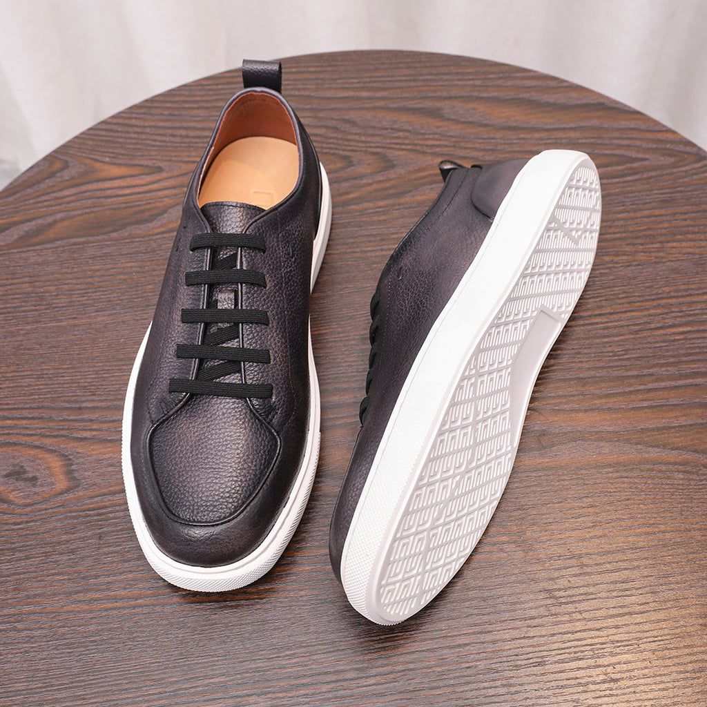 Black leather low-top sneakers, front and side view with textured white outsole