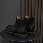 Men's pointed-toe Chelsea dress boots pair, black with elastic gore and brown-trim sole