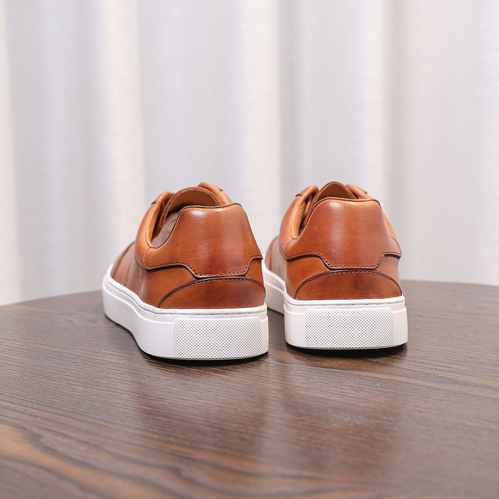 Brown genuine leather men's sneakers pair with back tabs and white rubber sole.