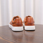 Brown genuine leather men's sneakers pair with back tabs and white rubber sole.