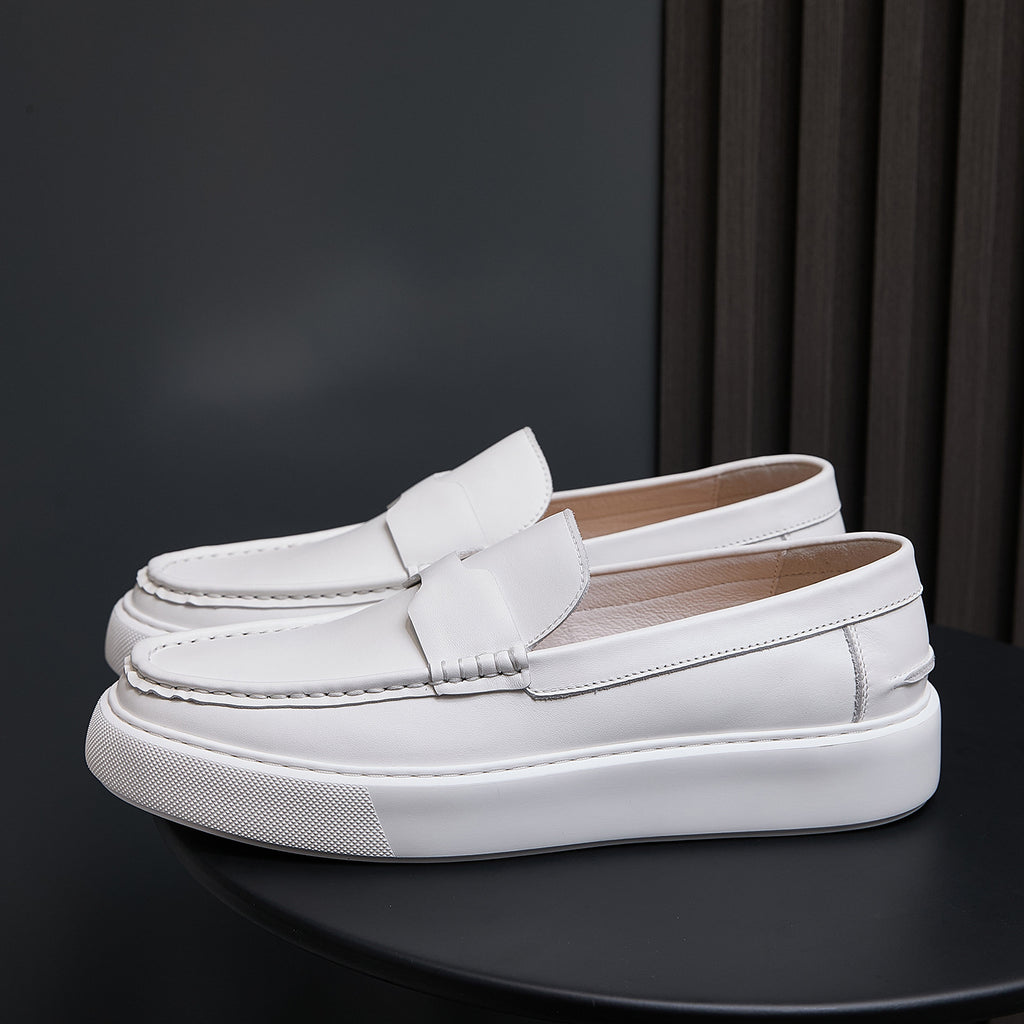 Men's white leather slip-on sneakers angled side view with textured white outsole edge.
