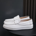 Men's white leather slip-on sneakers angled side view with textured white outsole edge.