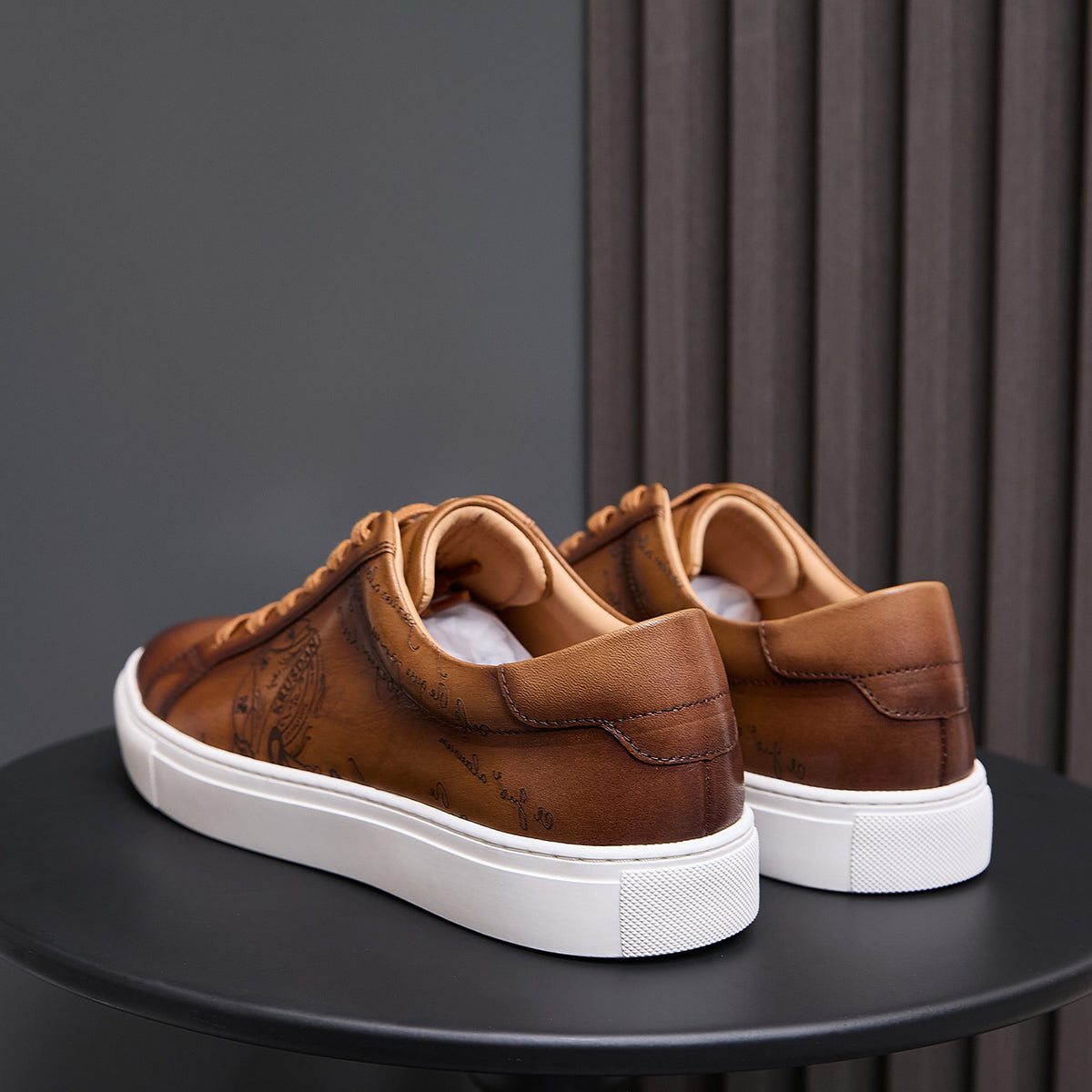 Men's tan leather sneakers back view with heel panel and white rubber sole