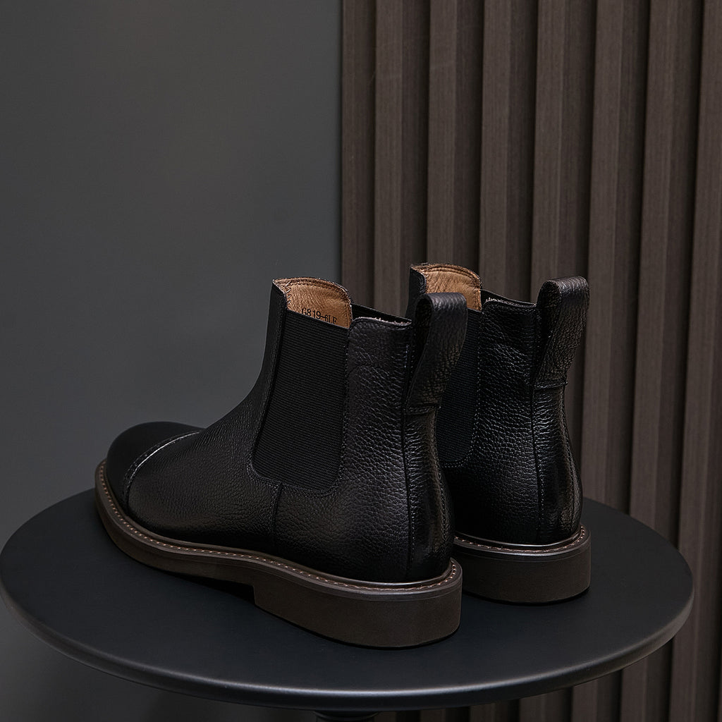 Men's black Chelsea dress boots, heel-and-side view with elastic stretch panels