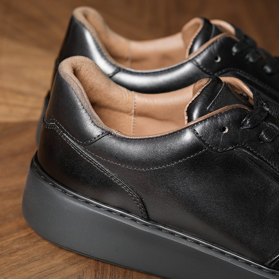 Black leather lace-up sneaker, round toe, stitched sole, low-profile platform.