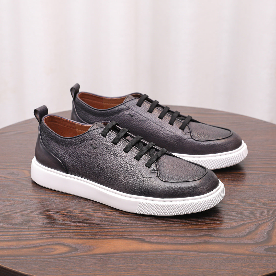 Dark gray/black leather low-top sneakers with lace-up front and white rubber sole