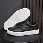 Black leather low-top sneakers with lace-up front and white rubber sole