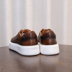 Men's dark brown leather sneakers, rear view with cushioned heel and white soles