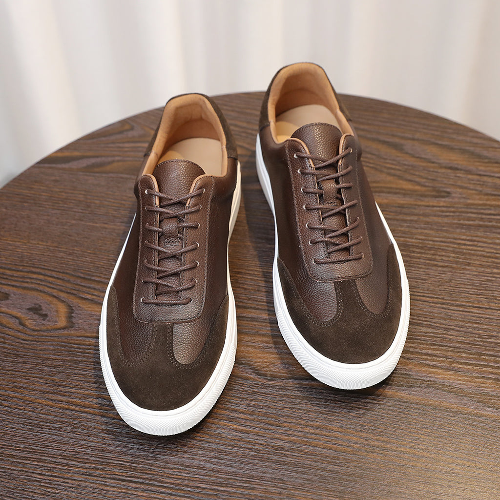 Men's dark brown leather sneakers with lace-up front, rounded toe, and white sole.